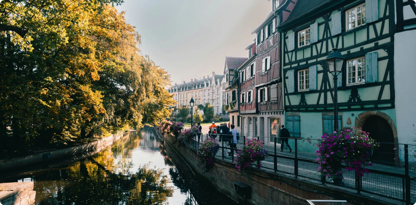 Un canal bordé de maisons à colombages et d’arbres en automne